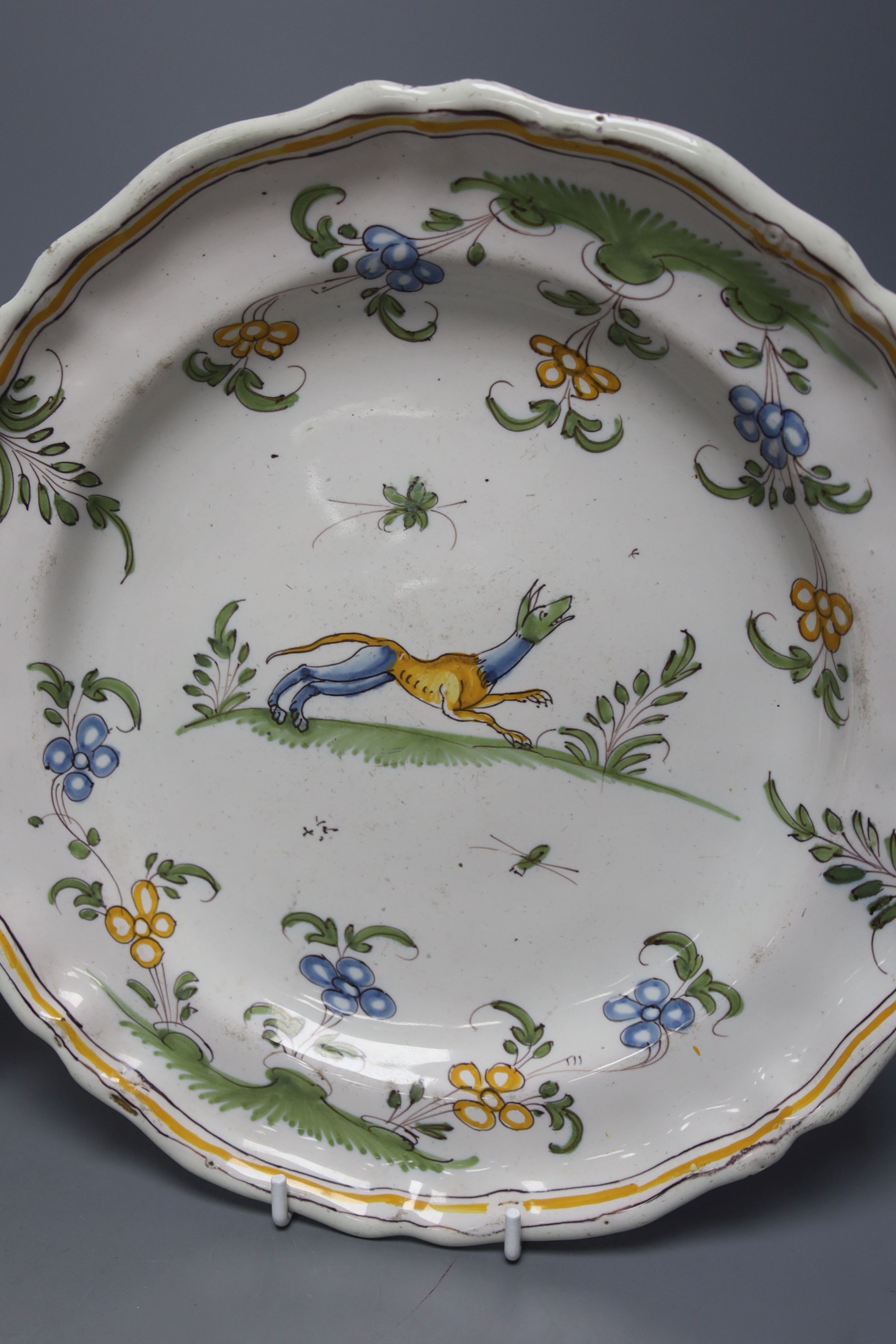 An 18th century Moustiers faience plate and a late 18th century Continental porcelain desert dish, plate 25 cms diameter.